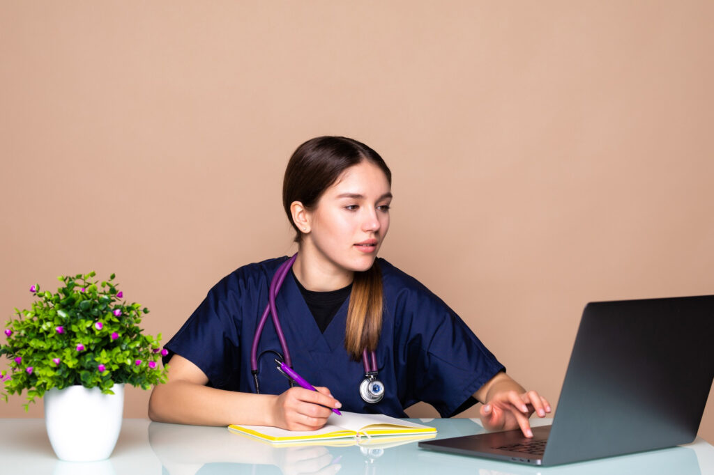 A cute woman searching on a computer for how to find affordable health insurance.