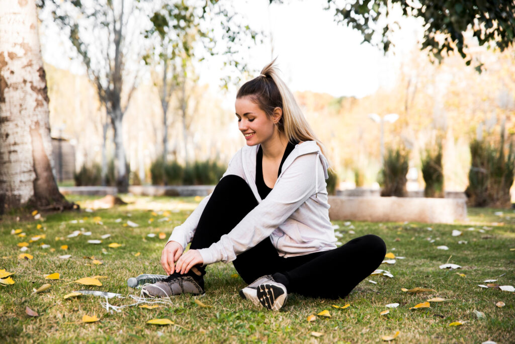 Person tying sneakers, symbolizing the first steps in starting an exercise routine